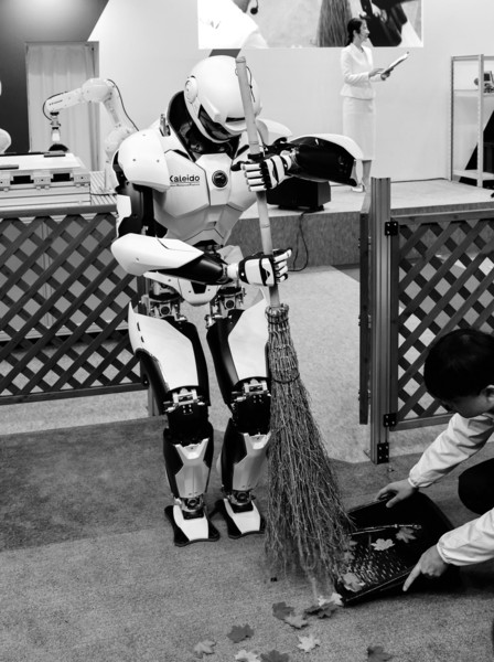 2025年12月3日,在日本东京的国际机器人展上,一个机器人展示使用扫帚清扫垃圾。新华社发